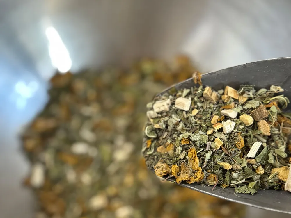 Teemischung in einer Metallschale mit Löffel – Tee für Ihr Weh-Weh aus der Ring-Apotheke